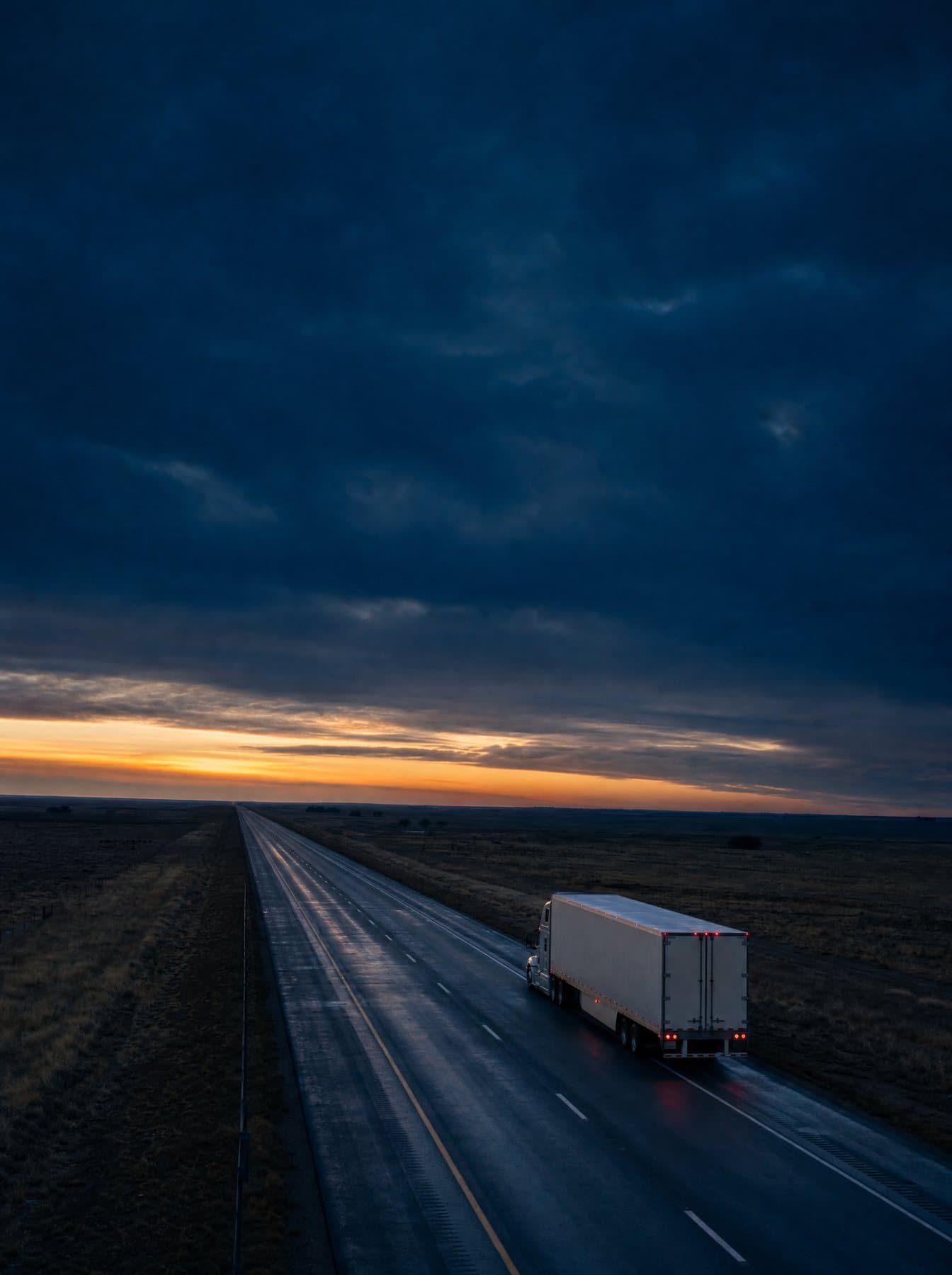 Tractor-trailer on an open interstate at dusk